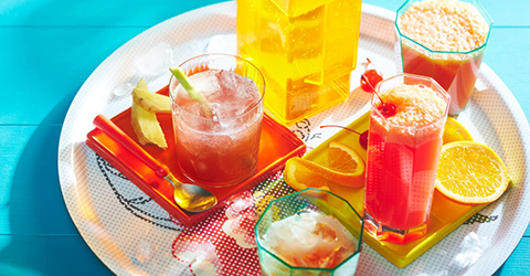 tropical sparkler and peachy sunrise mocktail drinks on a white round serving platter