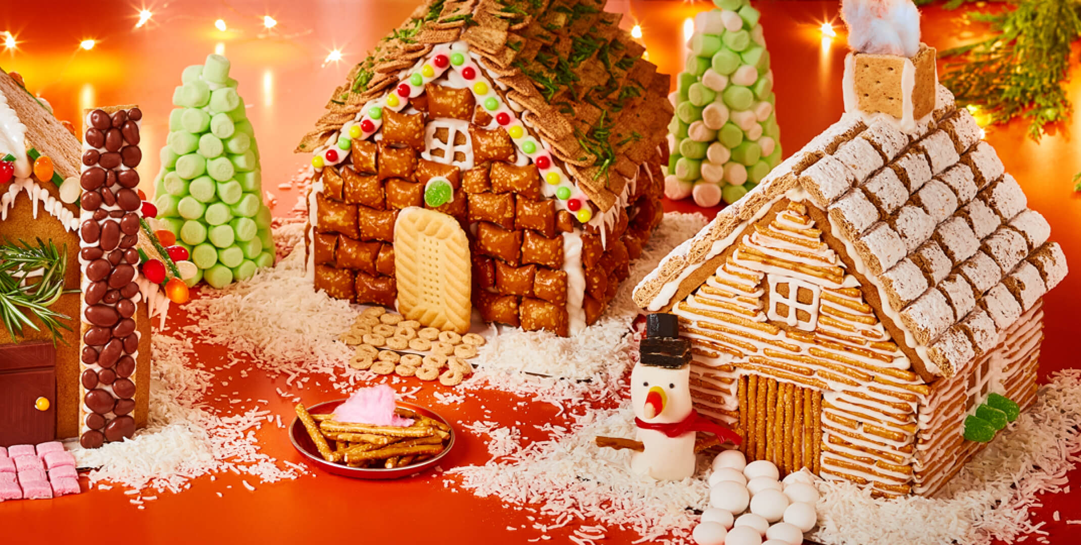 Photo of 3 gingerbread houses decorated in cottage, modern, and Victorian style.