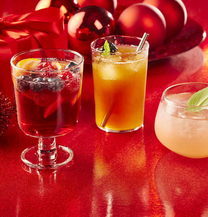 Sparkling sangria, festive iced tea and wintery citrus spritz on a red background.