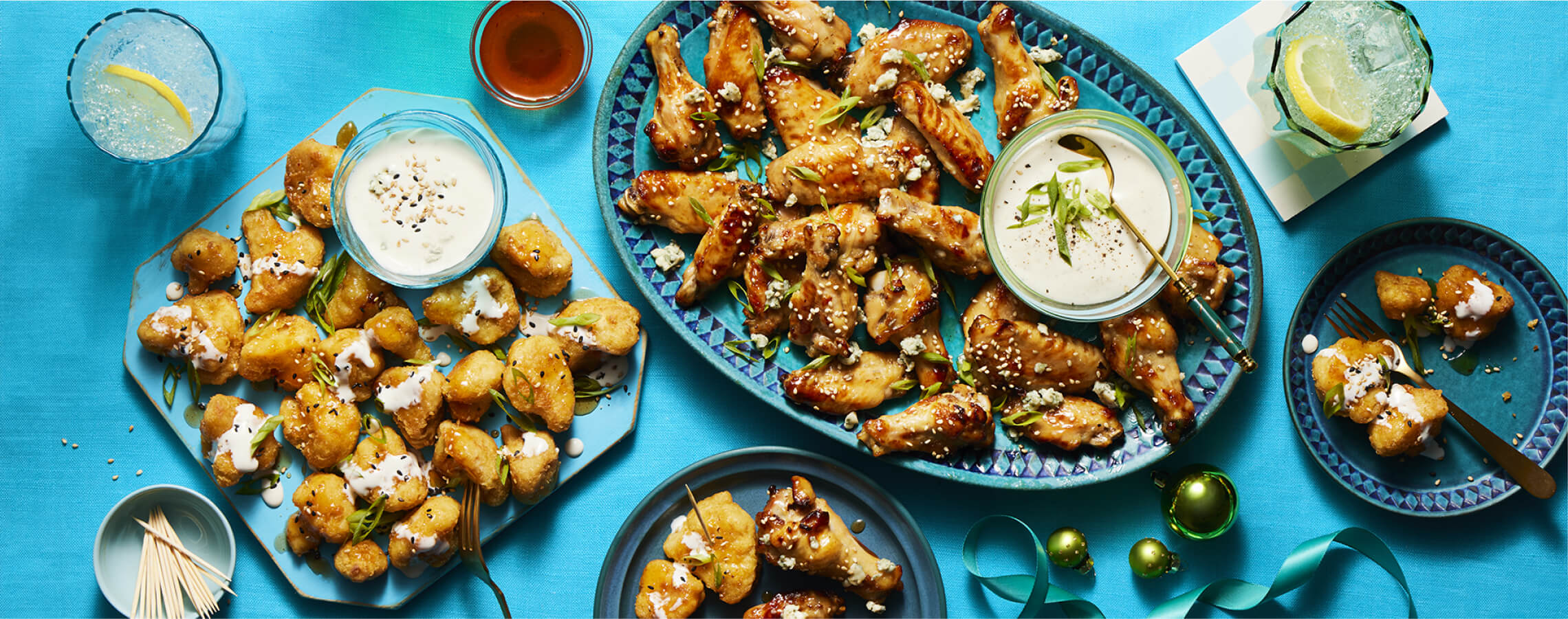 Platter of Hot Honey Chicken Wings and Hot Honey Cauliflower Bites with accompanying dips