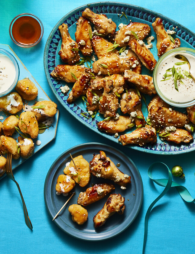 Platter of Hot Honey Chicken Wings and Hot Honey Cauliflower Bites with accompanying dips