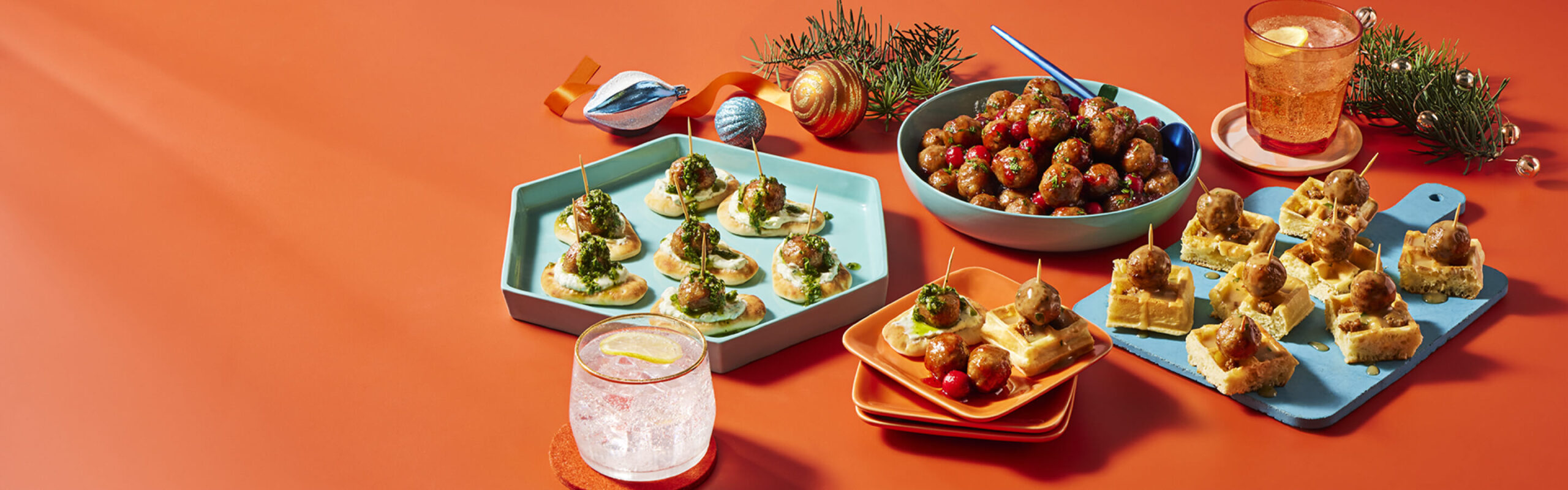 Compliments boulettes de poulet sur un mini-pita, gaufré et avec un glaçage aux canneberges sur un fond orange.