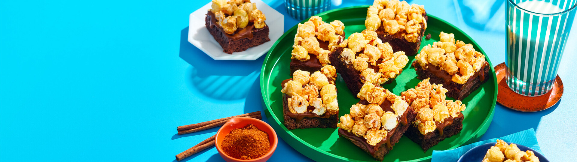 Mexican-spiced popcorn brownies on plates with a glass of milk