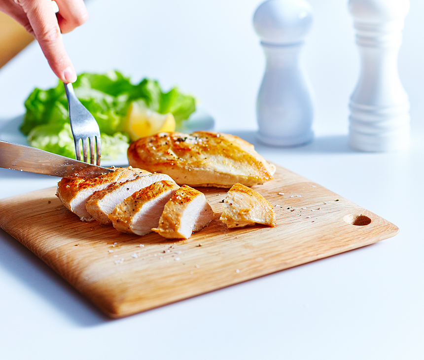 Poitrine de poulet tranchée sur une planche à découper